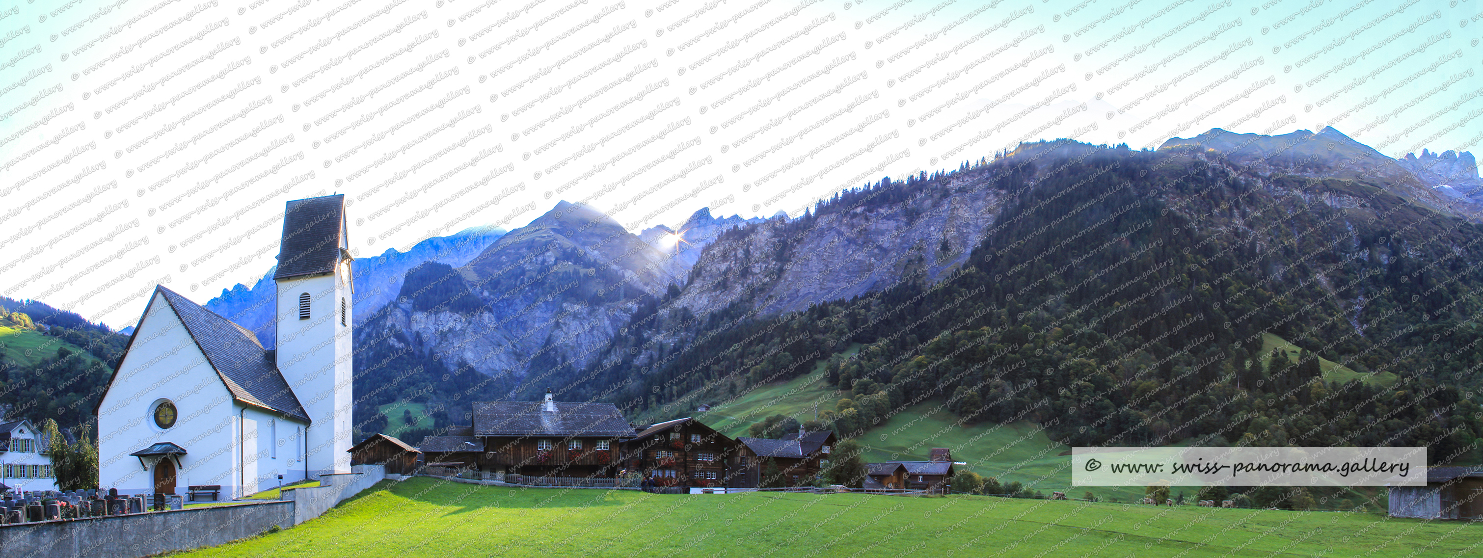 Schweizer Bergpanorama der Glarner Alpen, Elm, Martinsloch zum Zeitpunkt, wenn die Sonne durch das Martinsloch auf den Kirchturm von Elm scheint